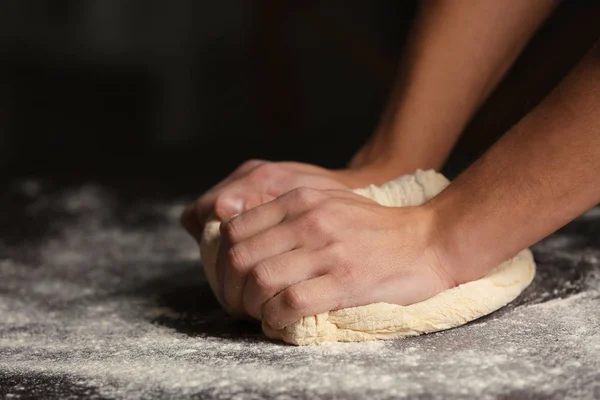 Mains masculines pétrissant la pâte — Photo