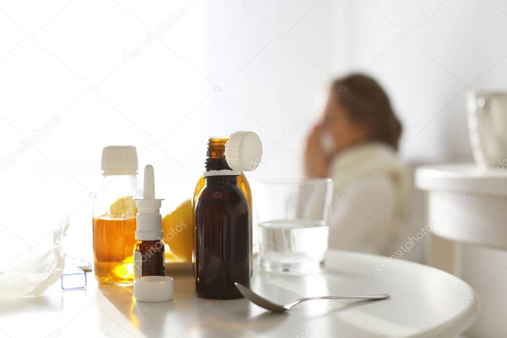 Set of medicines and blurred ill woman on background