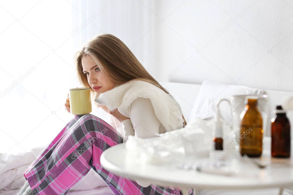 Young ill woman drinking tea