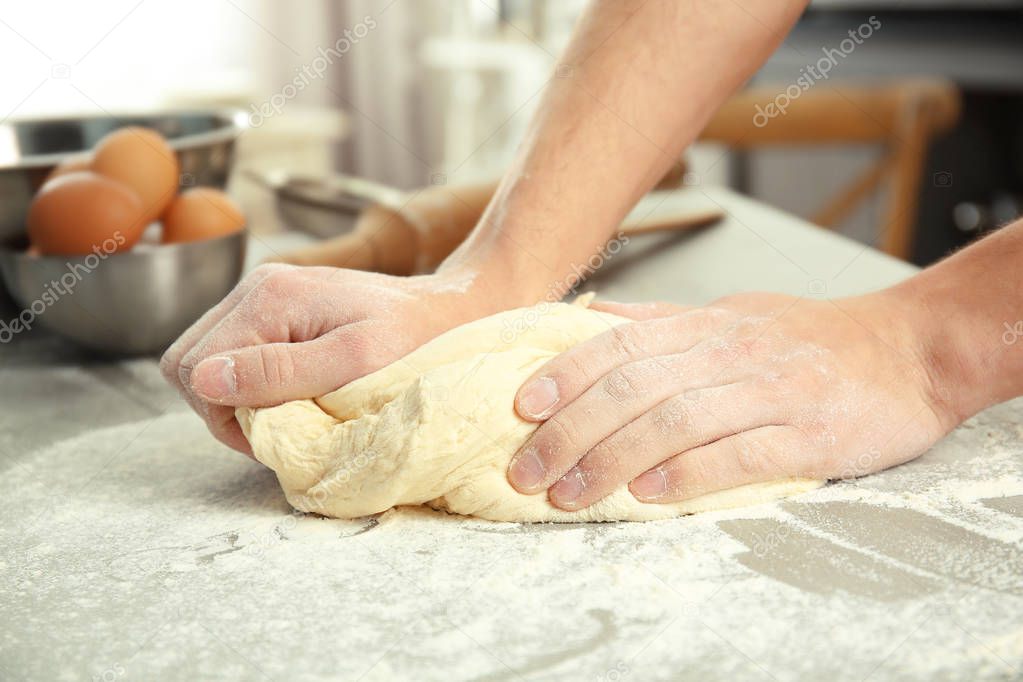 Male hands kneading dough 