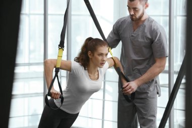 Rehabilitasyon kavramı. Genç kadın fizyoterapist gözetiminde egzersizleri yapıyor