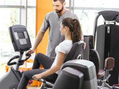 Rehabilitasyon kavramı. Genç kadın fizyoterapist gözetiminde egzersizleri yapıyor