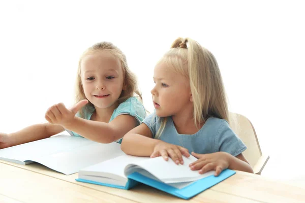 Schwestern machen gemeinsam Hausaufgaben am Tisch — Stockfoto