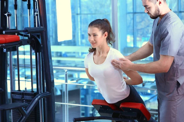 Revalidatie concept. Jonge vrouw doen oefeningen onder begeleiding van de fysiotherapeut — Stockfoto