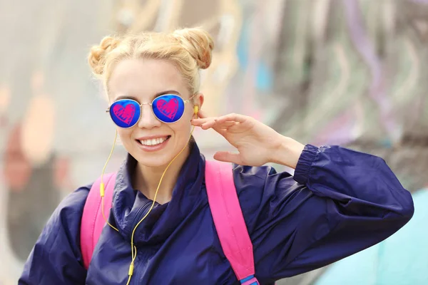 Jeune belle femme portant des lunettes de soleil avec des cœurs sur fond flou — Photo