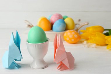 Ahşap masa ışık arka plan üzerinde renkli yumurtalı Paskalya tavşanları