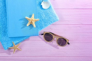 Kitap, güneş gözlüğü ve havlu pembe ahşap tablo