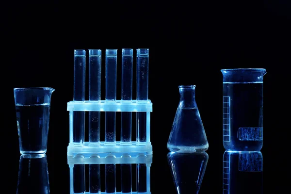 Chemical flasks and test-tubes on black background — Stock Photo, Image