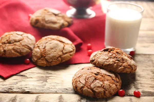 Вкусное шоколадное печенье, стакан молока и красная салфетка на деревенском деревянном столе, крупным планом — стоковое фото