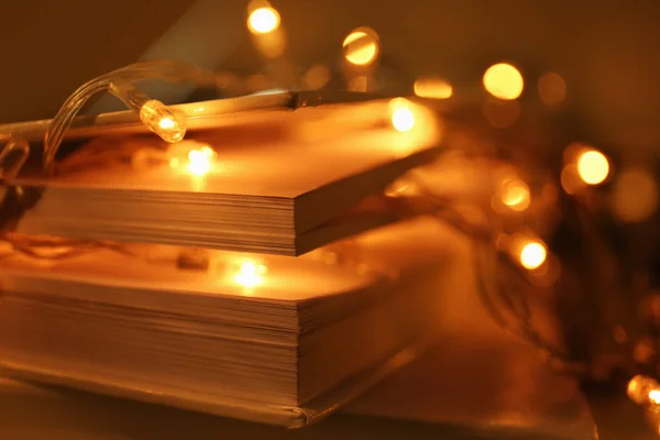 Close up view of books and beautiful garland on table — Stock Photo, Image