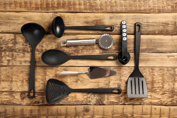 Набор различных кухонных инструментов на деревянном столе — стоковое фото