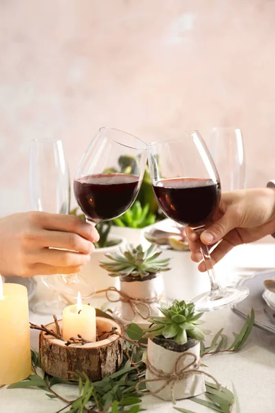 People toasting with glasses of red wine, closeup