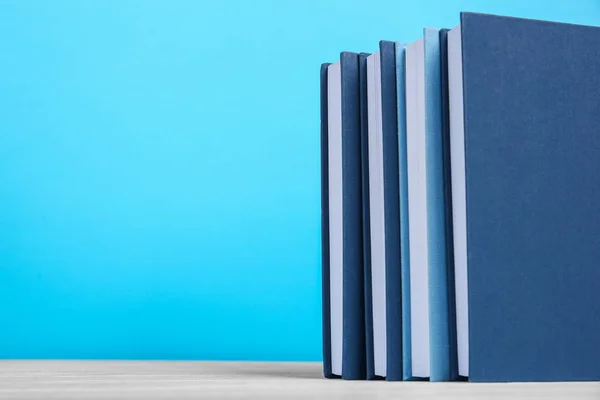 Livros sobre mesa de madeira e fundo azul — Fotografia de Stock