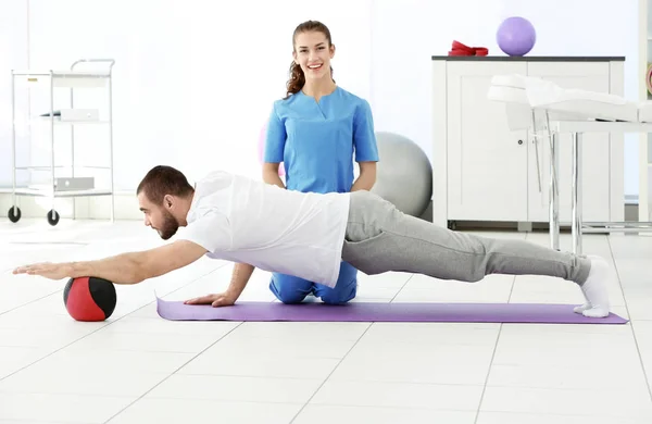 Fisioterapeuta que trabaja con el paciente en la clínica — Foto de Stock