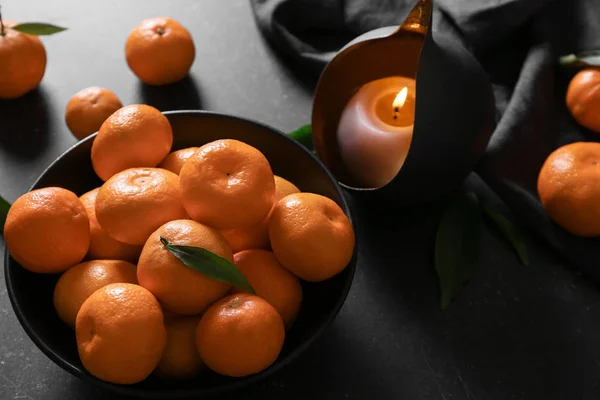 Tangerine in plaat met kaars op tafel — Stockfoto