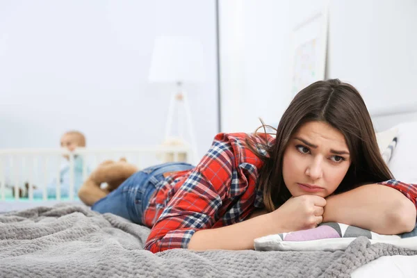 Wanita muda tertekan berbaring di tempat tidur di rumah — Stok Foto