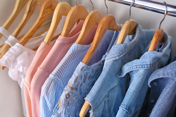 Close-up van hangers met verschillende kleding in kast — Stockfoto