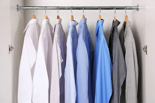 Close-up van hangers met verschillende shirts in kledingkast — Stockfoto