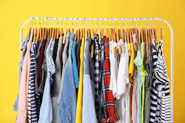 Sarı arka plan üzerinde renkli elbise askıları