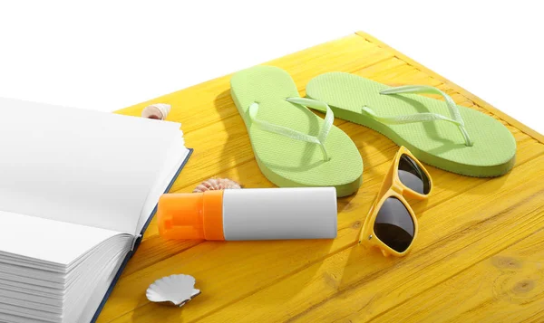 Concepto de vacaciones. Libro y chanclas sobre mesa de madera amarilla —  Fotos de Stock