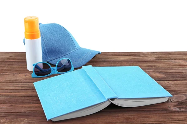 Concepto de vacaciones. Libro, gorra y crema protector solar sobre mesa de madera — Foto de Stock