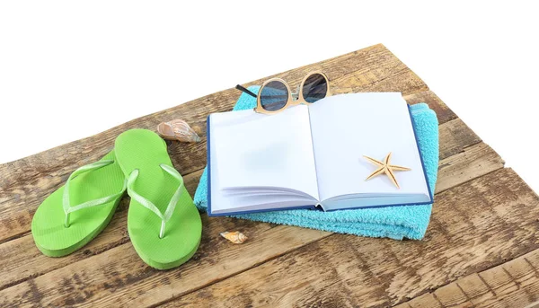 Concepto de vacaciones. Libro abierto, chanclas, gafas de sol y toalla sobre mesa de madera —  Fotos de Stock