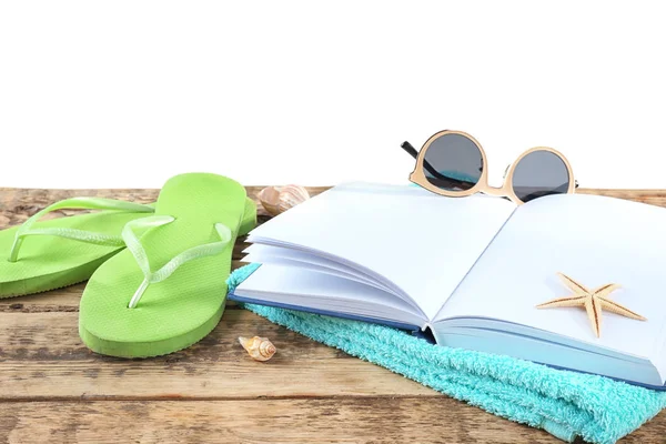 Concepto de vacaciones. Libro abierto, chanclas, gafas de sol y toalla sobre mesa de madera —  Fotos de Stock