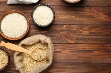 Çanta, kaşık ve ahşap masa üzerinde kase pirinç