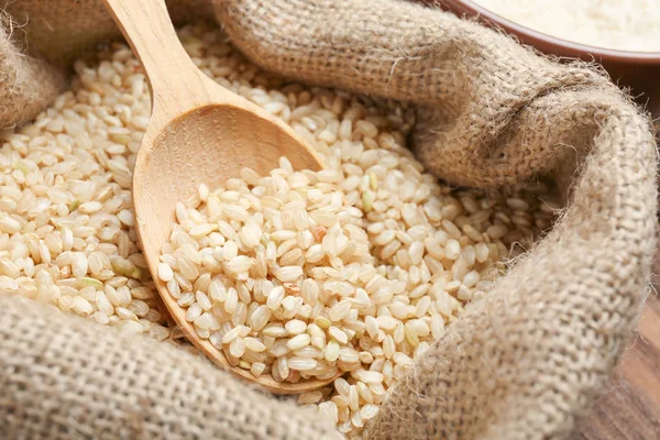 Colher no saco cheio de arroz, close-up — Fotografia de Stock