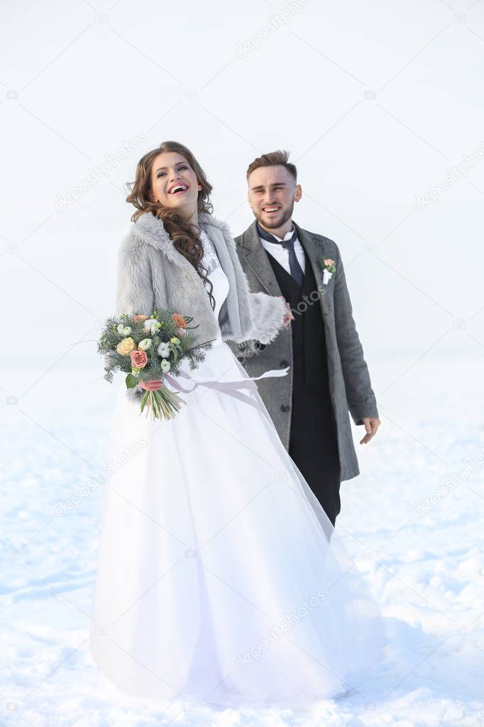 Happy wedding couple outdoors on winter day