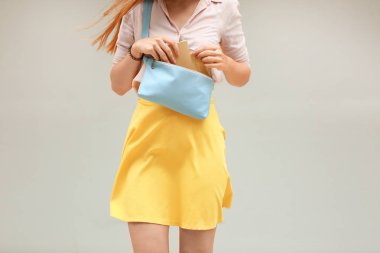 Mavi deri debriyaj ışık arka plan üzerinde tutan genç kadın