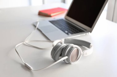 Masada kulaklık ve dizüstü bilgisayar var.