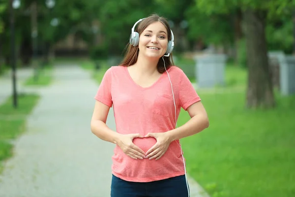 Mujer embarazada escuchando música — Foto de Stock