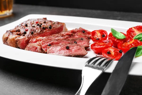 Gesneden biefstuk met kruiden en tomaten — Stockfoto