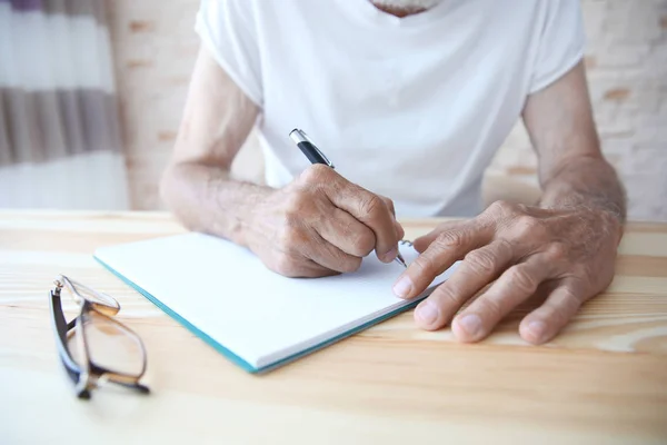 Männliche Hände schreiben in Textbuch — Stockfoto