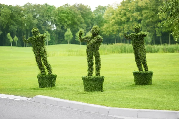 Three bushes in shape of people