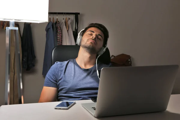 Ο άνθρωπος με τα ακουστικά στον ύπνο σε καρέκλα — Φωτογραφία Αρχείου