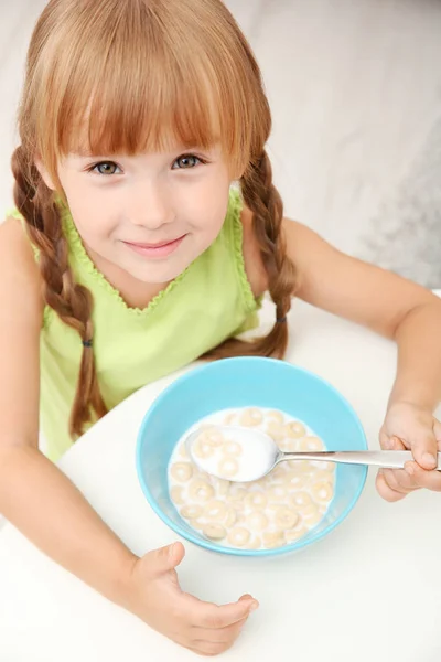 Маленькая девочка ест кукурузные хлопья — стоковое фото