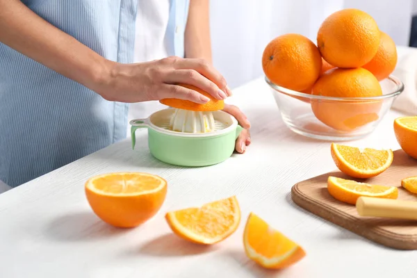 Hembra manos exprimiendo jugo de naranja — Foto de Stock