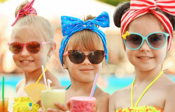 Kleine Mädchen mit Cocktails am sonnigen Tag im Schwimmbad — Stockfoto