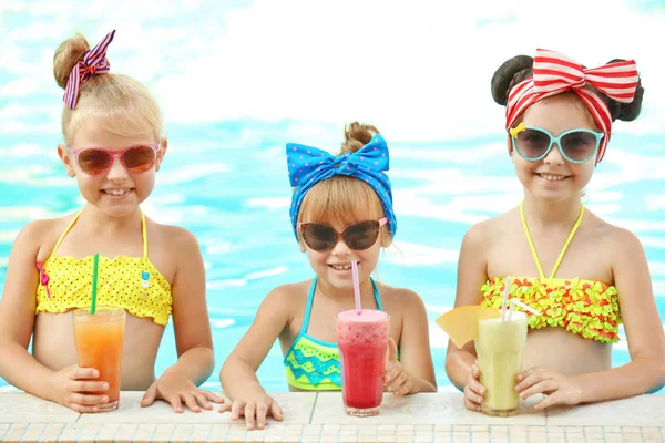 Kleine Mädchen mit Cocktails im Schwimmbad an sonnigem Tag — Stockfoto