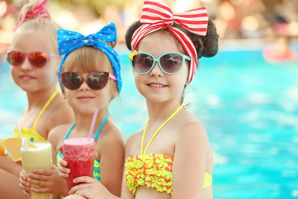 Kleine Mädchen mit Cocktails am sonnigen Tag im Schwimmbad — Stockfoto