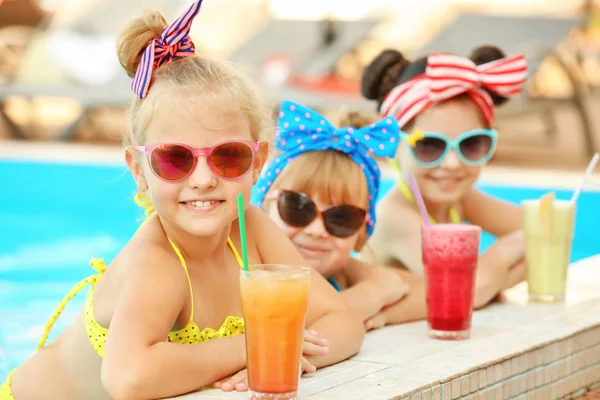 阳光明媚的日子, 小女孩在游泳池里喝着鸡尾酒 — 图库照片