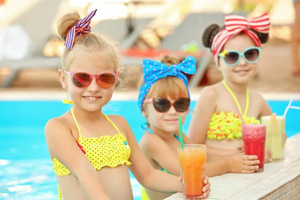 Kleine Mädchen mit Cocktails im Schwimmbad an sonnigem Tag — Stockfoto