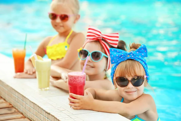 Kleine Mädchen mit Cocktails im Schwimmbad an sonnigem Tag — Stockfoto