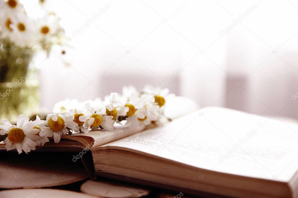Beautiful chamomile wreath on book