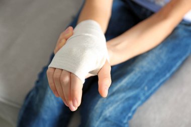 Kız elini bandaj ile