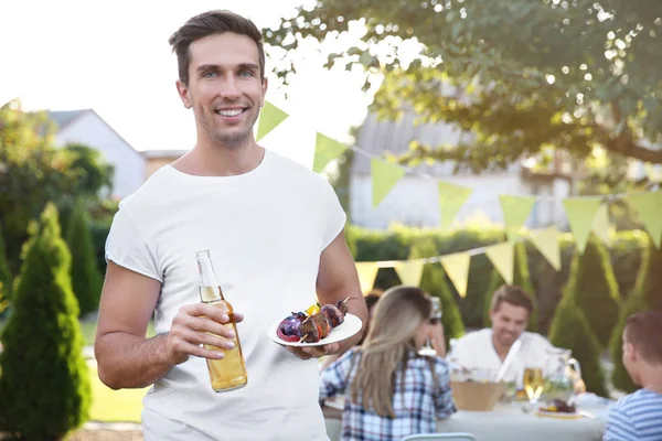 Man holding bottle and plate — Stock Photo, Image