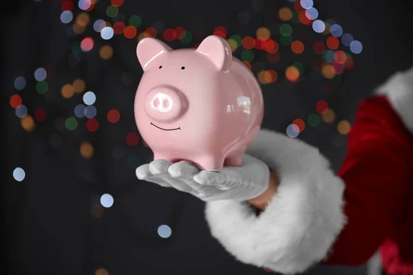 Santa Claus Hand hält Sparschwein — Stockfoto