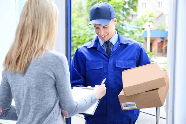 Young woman signing for package — Stock Photo, Image